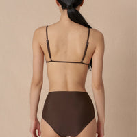 A high-waisted brown sustainable swimwear bikini bottom with minimalist design and moderate coverage, modelled by a woman in a matching bikini top.