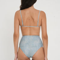 woman wearing flattering high waist bikini bottoms in blue green colour, sustainable swimwear for active women