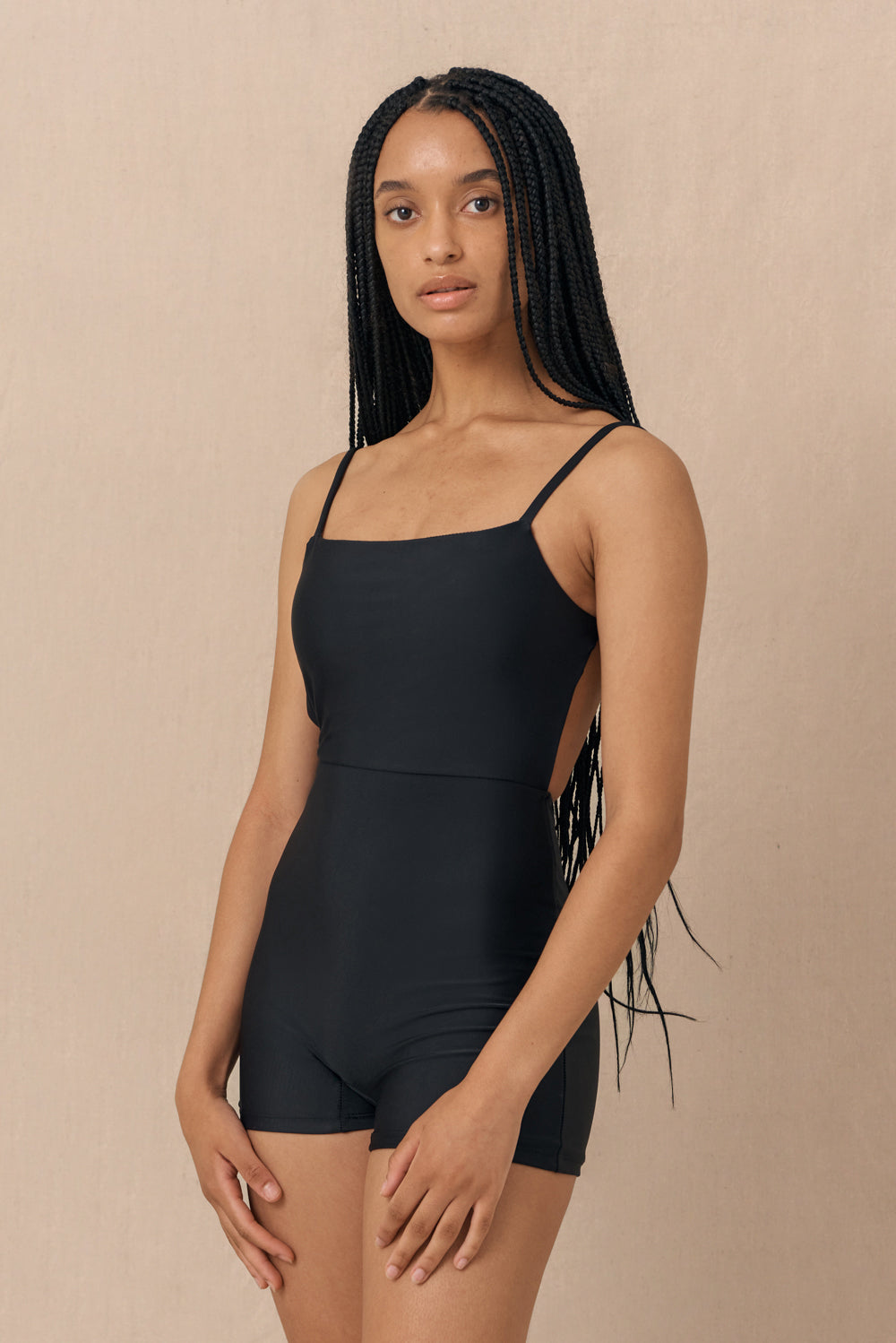 Model wearing black Terrain One Piece surf suit — sustainable swimwear designed for support and comfort in the surf, flattering one piece surf suit for active women.