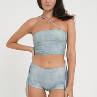 woman wearing minimalist blue green tankini top and matching low rise swim shorts, sustainable swimwear to swim and surf in.