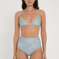 woman wearing flattering high waist bikini bottoms in blue green colour, sustainable swimwear for active women