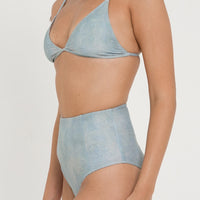 woman wearing fixed triangle bikini top in sea glass print, designed for both style and comfort. Crafted from 78% recycled nylon and 22% Lycra, offering a supportive and quick-drying fabric. Worn with matching high waisted sustainable swimwear bottoms.